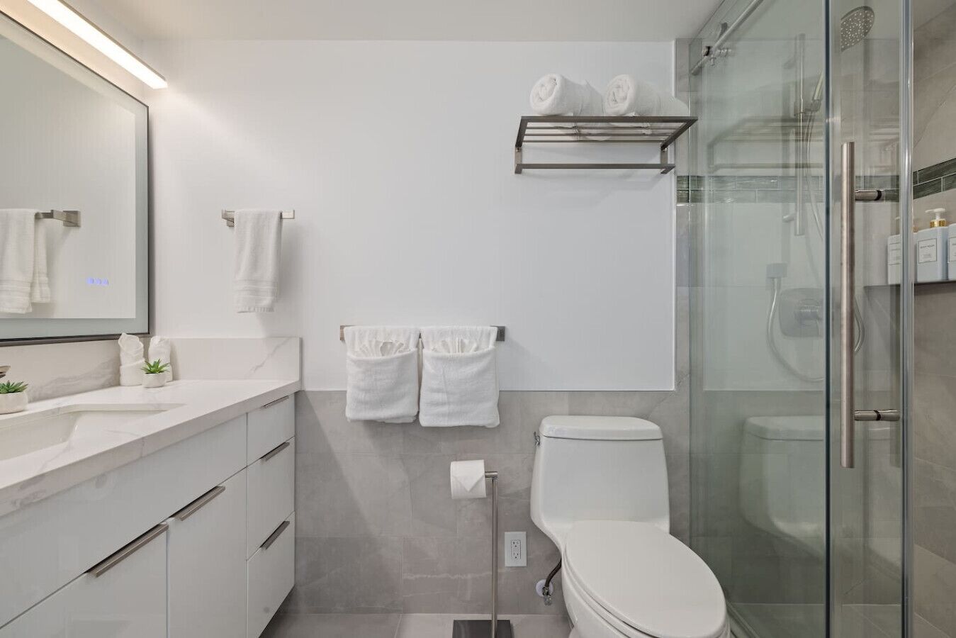A modern bathroom with a toilet, sink, and shower area.