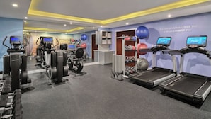 Et moderne fitnesscenter med løbebånd, crosstrainere og håndvægte.