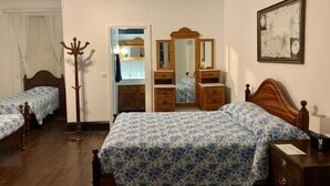 A bedroom with two single beds, a wooden dresser, a mirror, and a coat rack. - VCGuesthouse Grandfather's Room (Funchal)