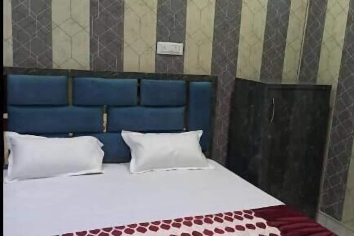 A bedroom with a bed, a headboard, and a wardrobe.