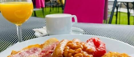 A breakfast plate with eggs, bacon, sausages, beans, and toast.