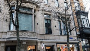 Een historisch gebouw met klassieke architectuur, grote ramen en een hoingang.