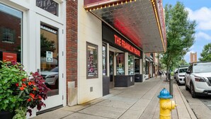 A theater building with a marquee reading "THEATRE" and "THE FRANKLIN THEATRE" below. - The Yellow Door Home for 8 (Franklin)