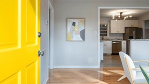A modern kitchen with white cabinets, a stainless steel refrigerator, and a marble countertop. - The Yellow Door Home for 8 (Franklin)