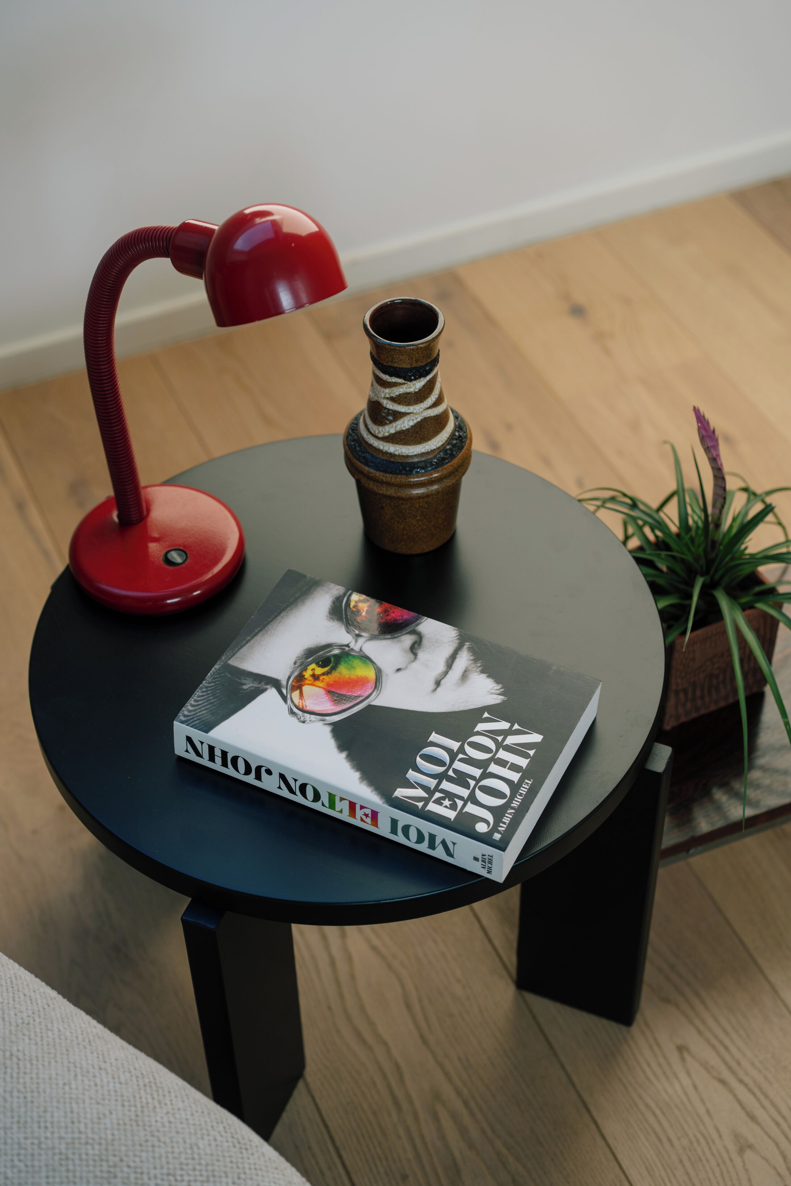 A round table with a book titled "Nihonga: The Art of Japanese Brushwork" and a red desk lamp.