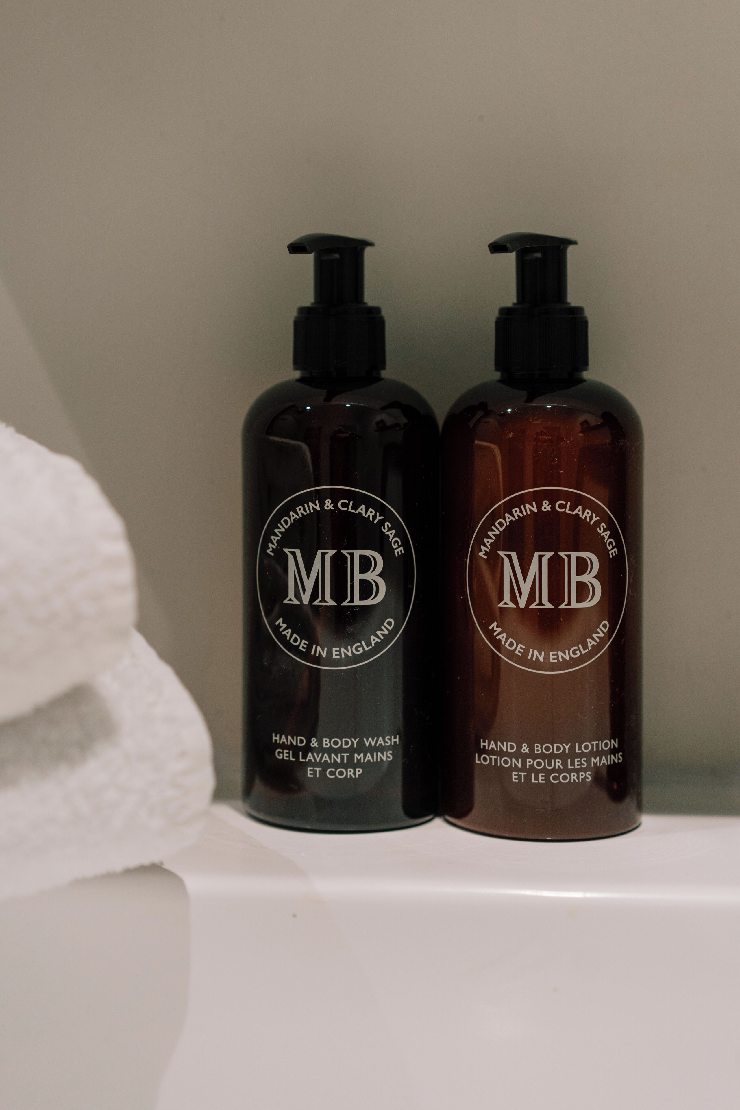 Two bottles of hand and body lotion on a shelf.