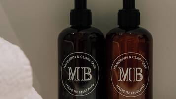Two bottles of hand and body lotion on a shelf.