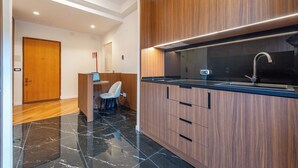 Eine moderne Küche mit Holzschränken, einer schwarzen Arbeitsplatte und einem Edelstahlspülbecken.