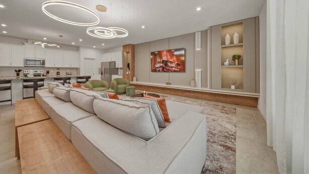 A modern kitchen with white cabinets, a built-in microwave, and a large island. - 9BR house sleeps 26 with spa in kissimmee (Kissimmee)