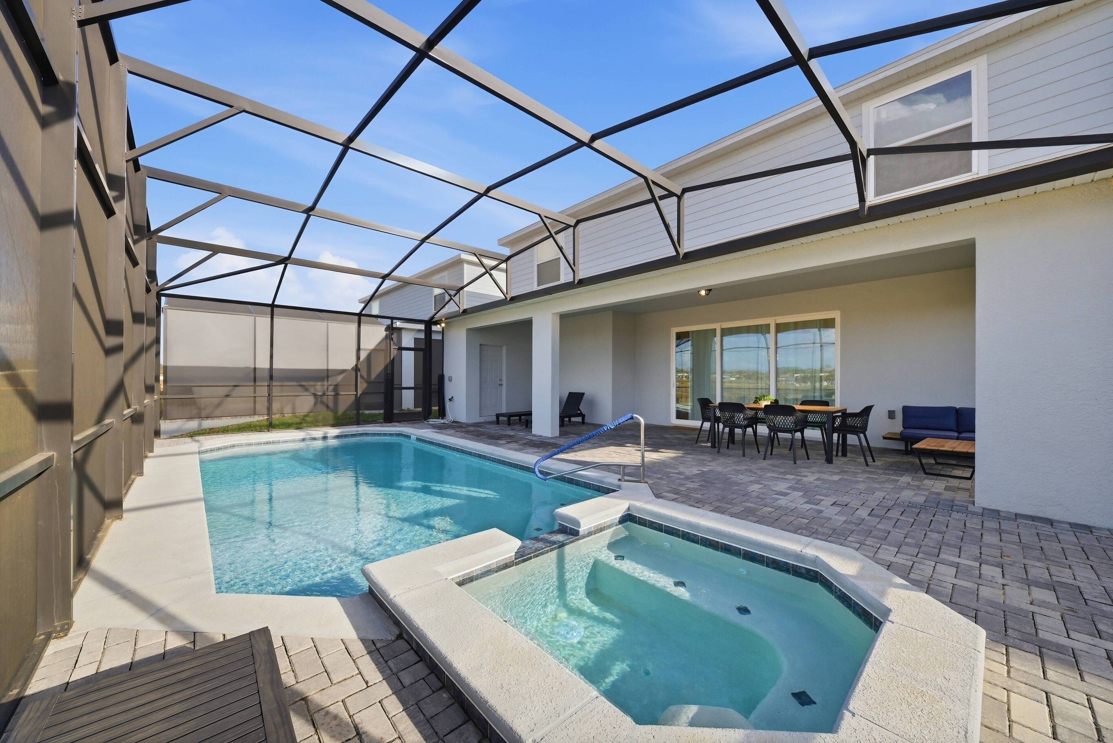 A rooftop pool with a glass ceiling, surrounded by outdoor seating and a patio area.