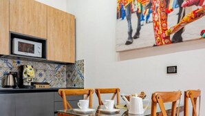 Une cuisine moderne avec des meubles en bois, un four à micro-ondes et une table à manger avec des chaises.