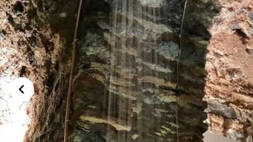 Una fontana in pietra con una cascata.