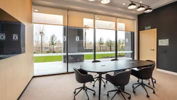 A conference room with a large table, four chairs, and a door labeled 'SALIDA'.