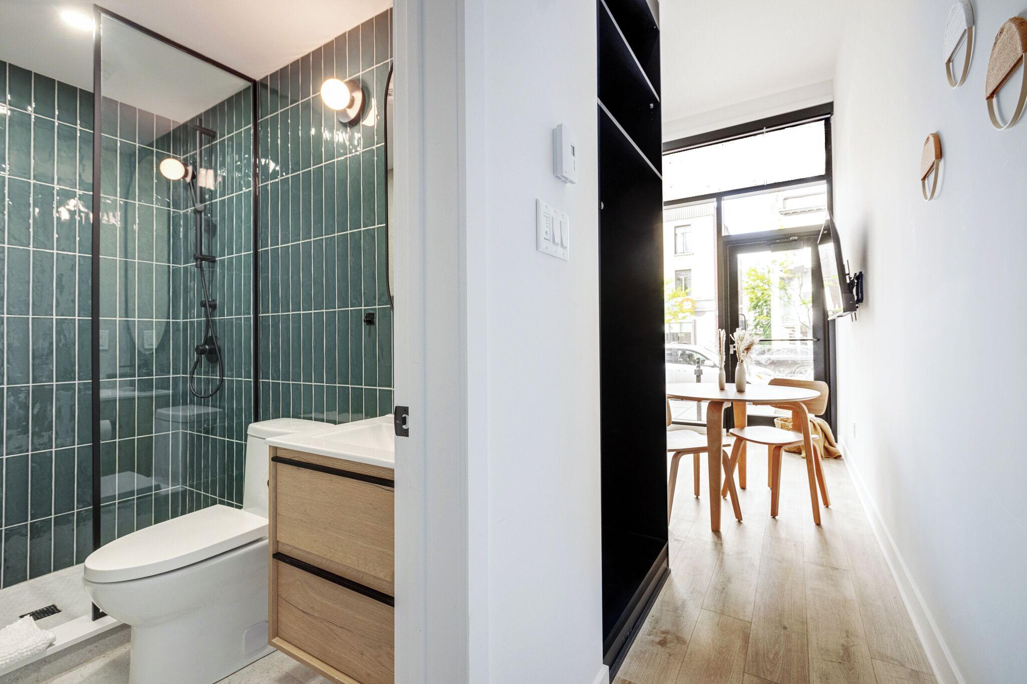 A modern bathroom with a glass shower enclosure and a wooden vanity.