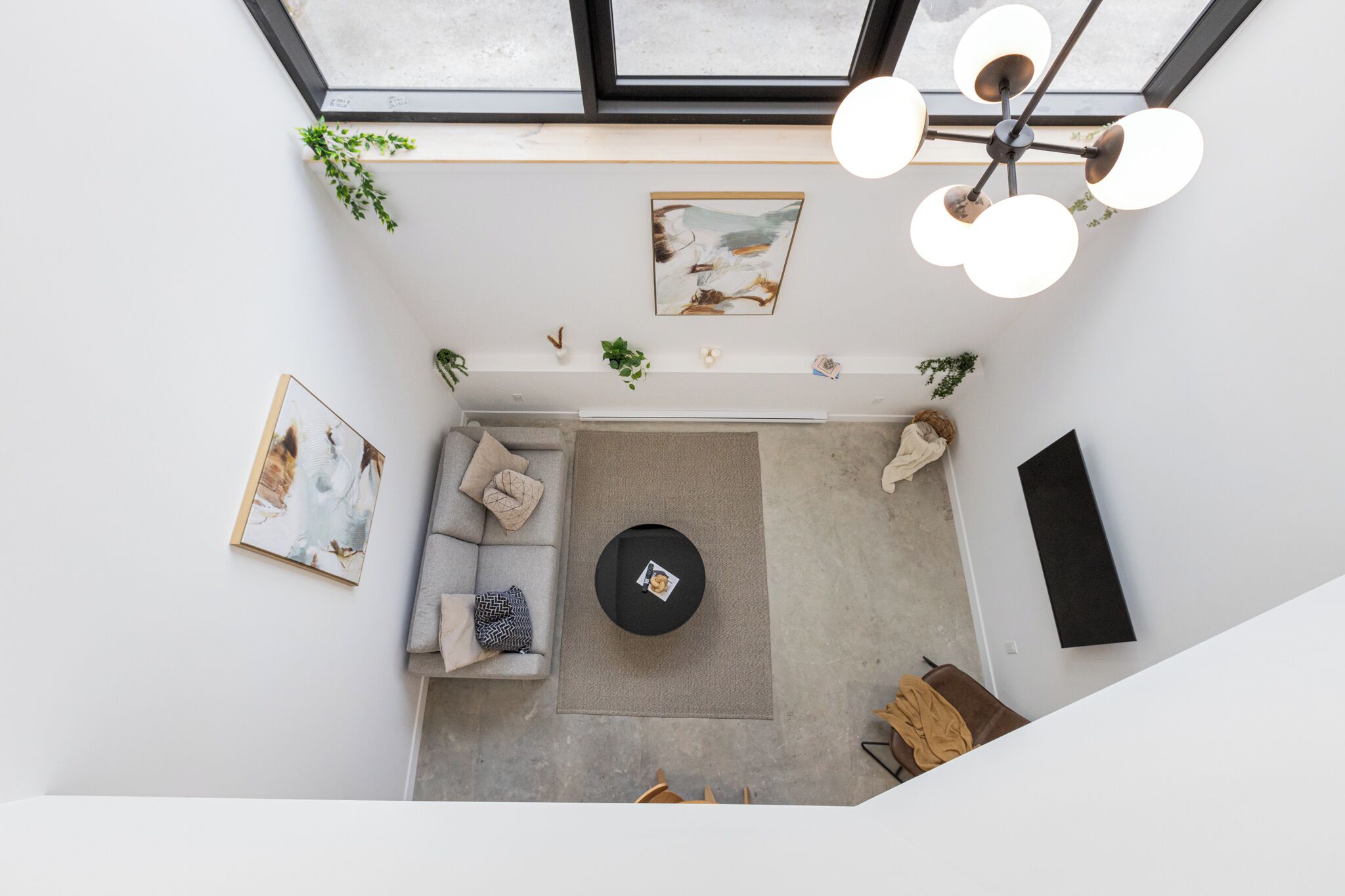 A modern living room with a sofa, a coffee table, and a ceiling fan.