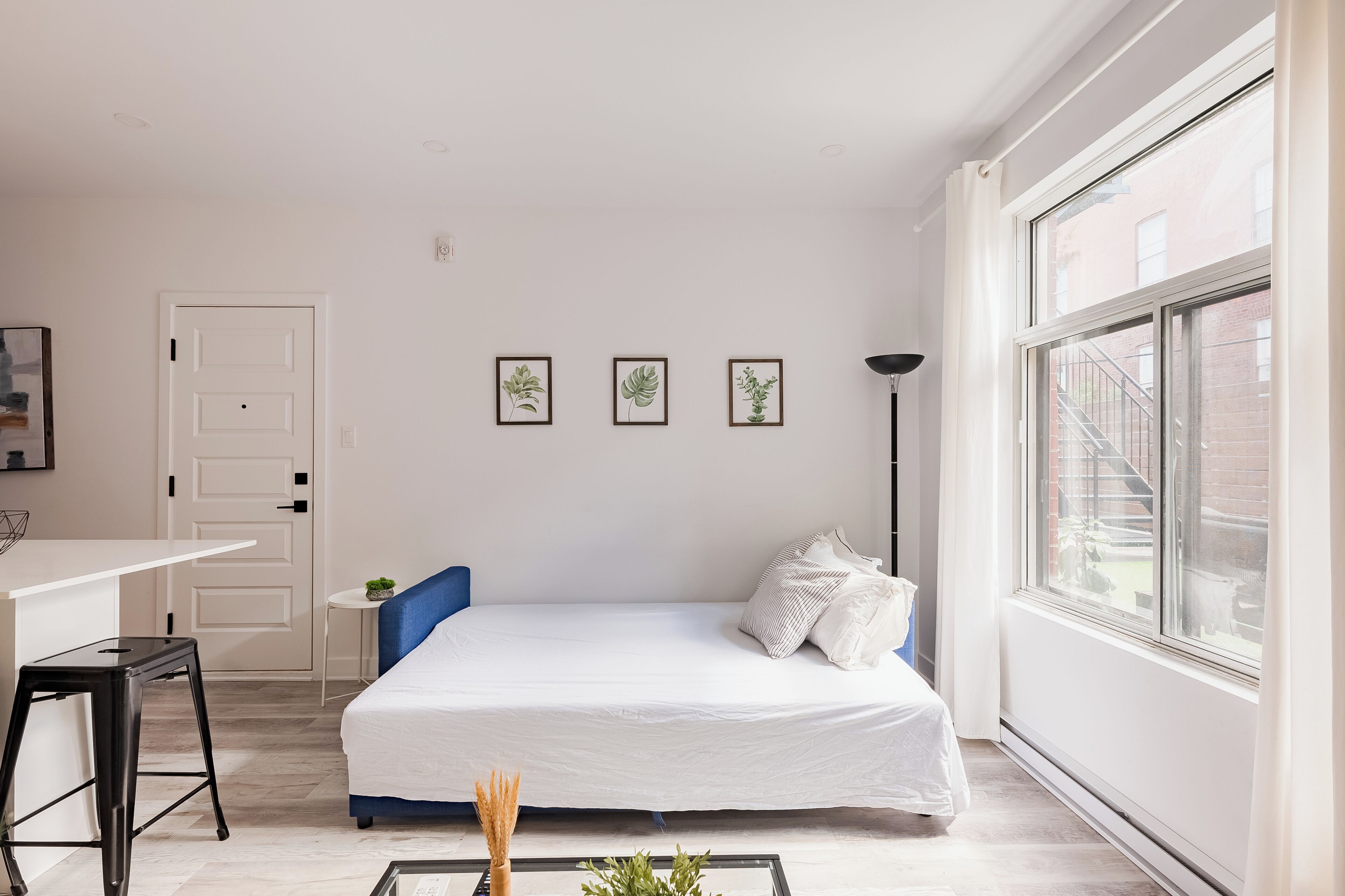 A bedroom with a bed, a desk, a chair, and a window.