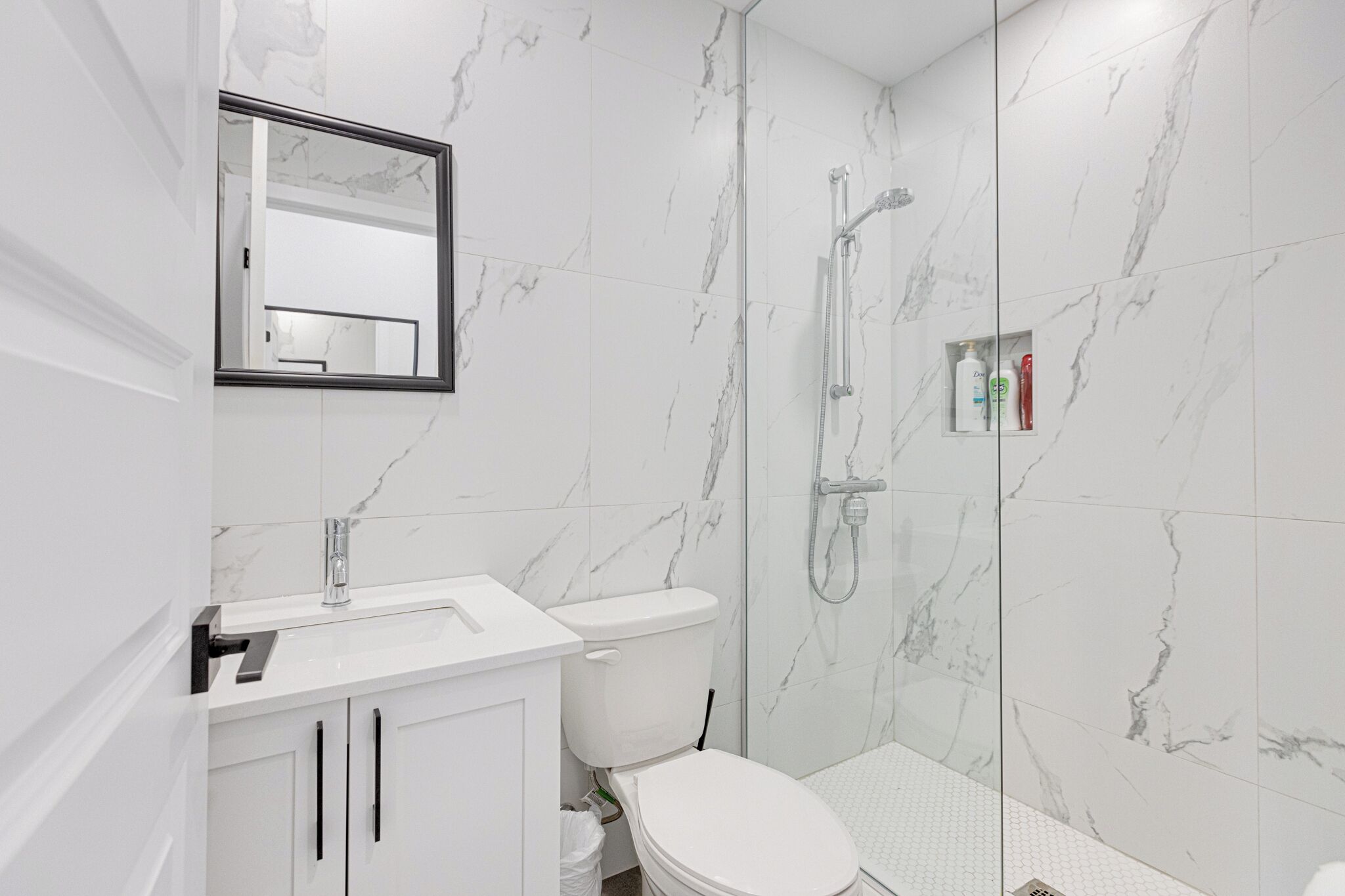 Une salle de bain moderne équipée de toilettes, d’un lavabo et d’une douche.