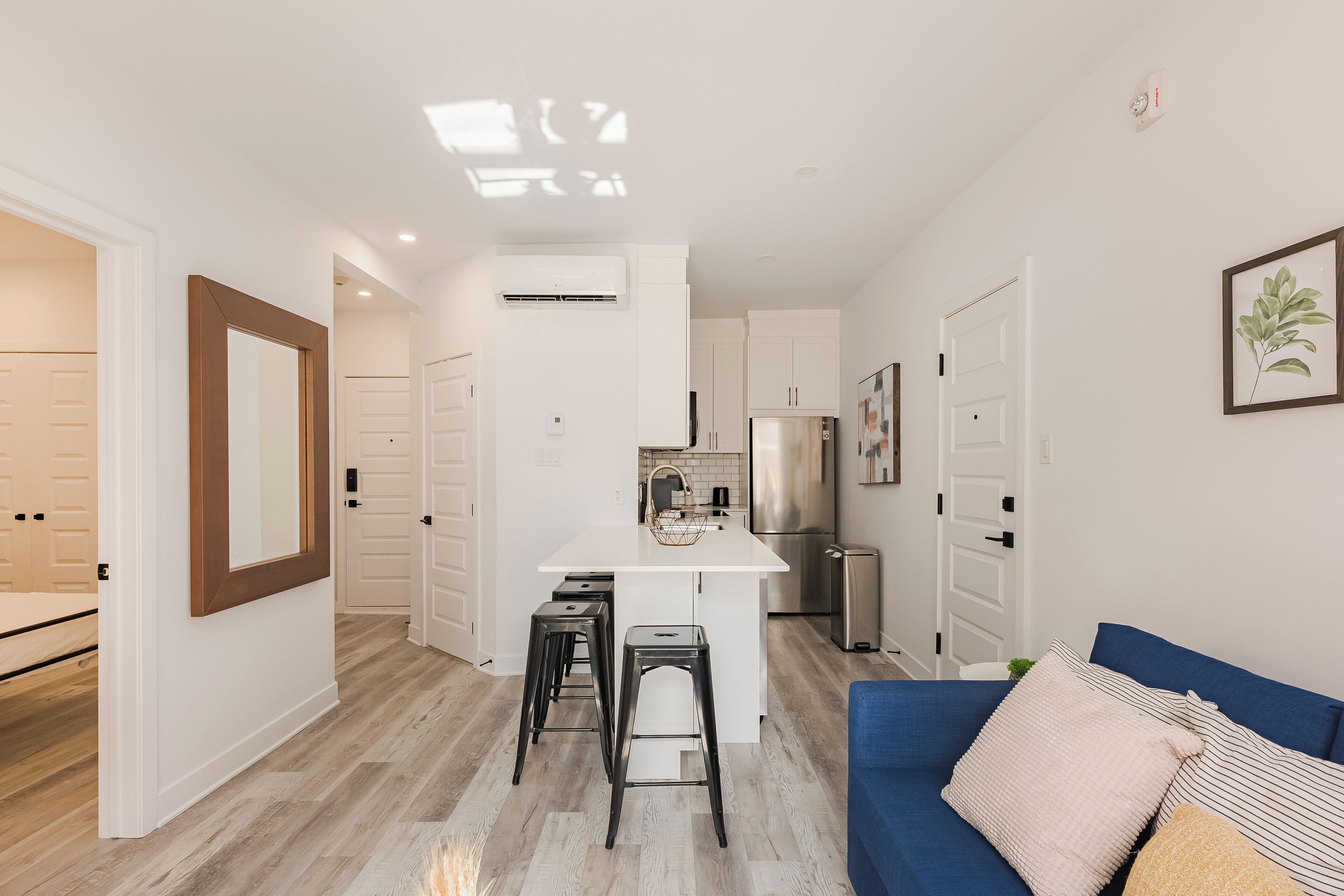A modern apartment with a kitchen, a dining area, and a living room.