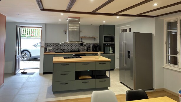 A modern kitchen with a central island, built-in appliances, and a dining area with a table and chairs. - Large family home with extensive grounds (Tortebesse)