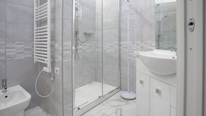 A modern bathroom with a glass-enclosed shower, a pedestal sink, and a vanity with cabinets. - VI DOMUS VATICAN MUSEUM GUEST HOUSE ROMA (Rome)