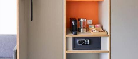 A modern, minimalist closet with multiple compartments, including shelves for storage and a hanging rack.