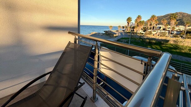 Un balcon avec vue sur la mer et sur une ville côtière.