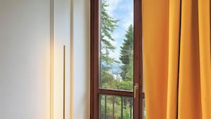 A window with a view of trees and a clear sky. - Raphael Stresa (Stresa)