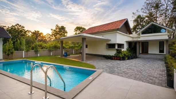 A modern house with a swimming pool, covered patio, and a well-maintained garden.