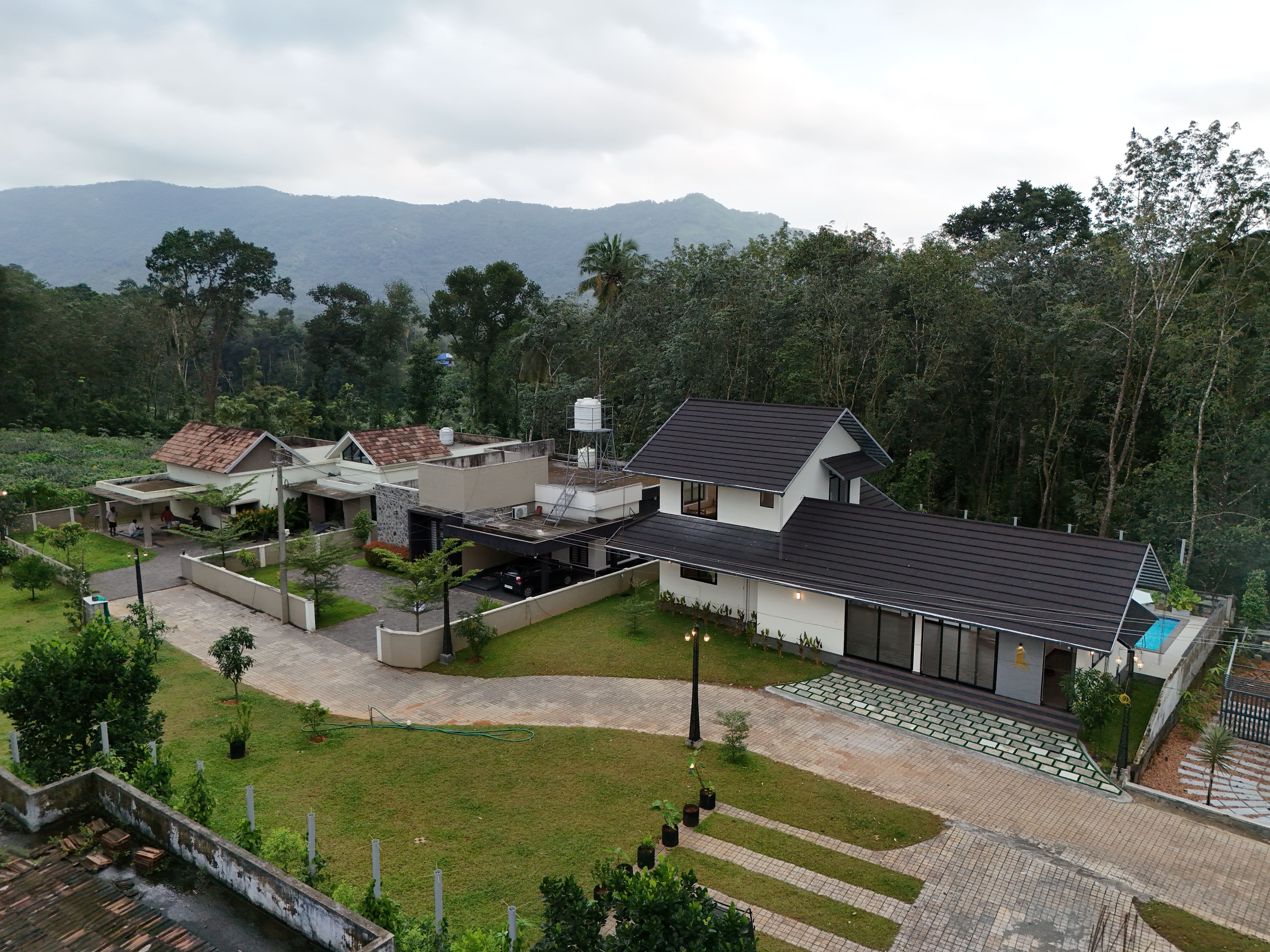Um complexo residencial moderno com várias casas, caminhos pavimentados e um paisagismo verde exuberante.