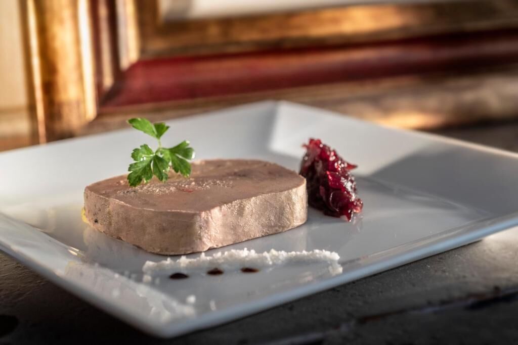 A plate with a terrine and a berry compote.