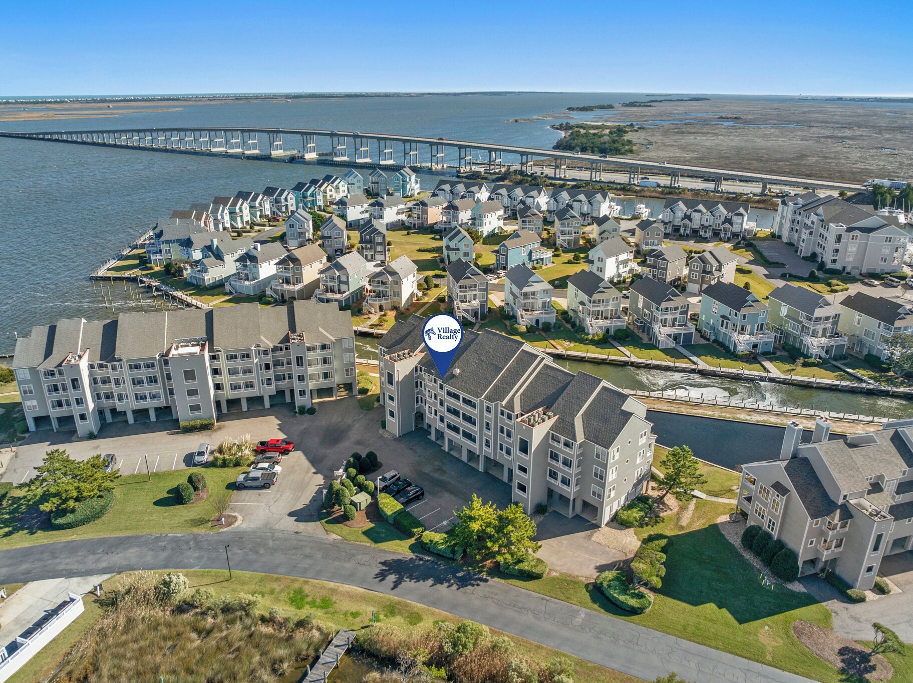 Vista aérea de una zona residencial con casas, un puerto deportivo y un puente.