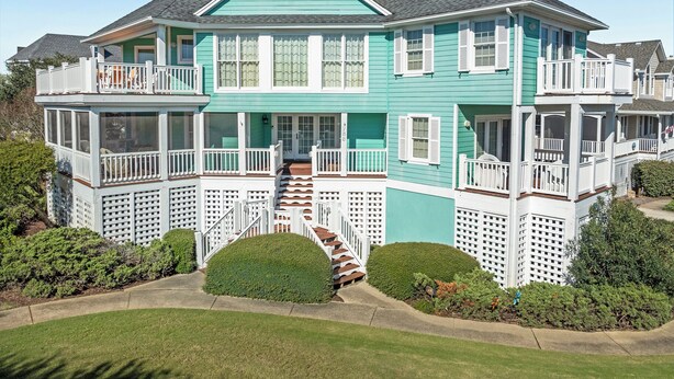A two-story house with a balcony, a chimney, and a well-maintained lawn. - Apollo Sunset: Elevator (Corolla)