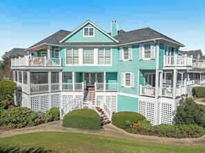 A two-story house with a balcony, a chimney, and a well-maintained lawn. - Apollo Sunset: Elevator (Corolla)