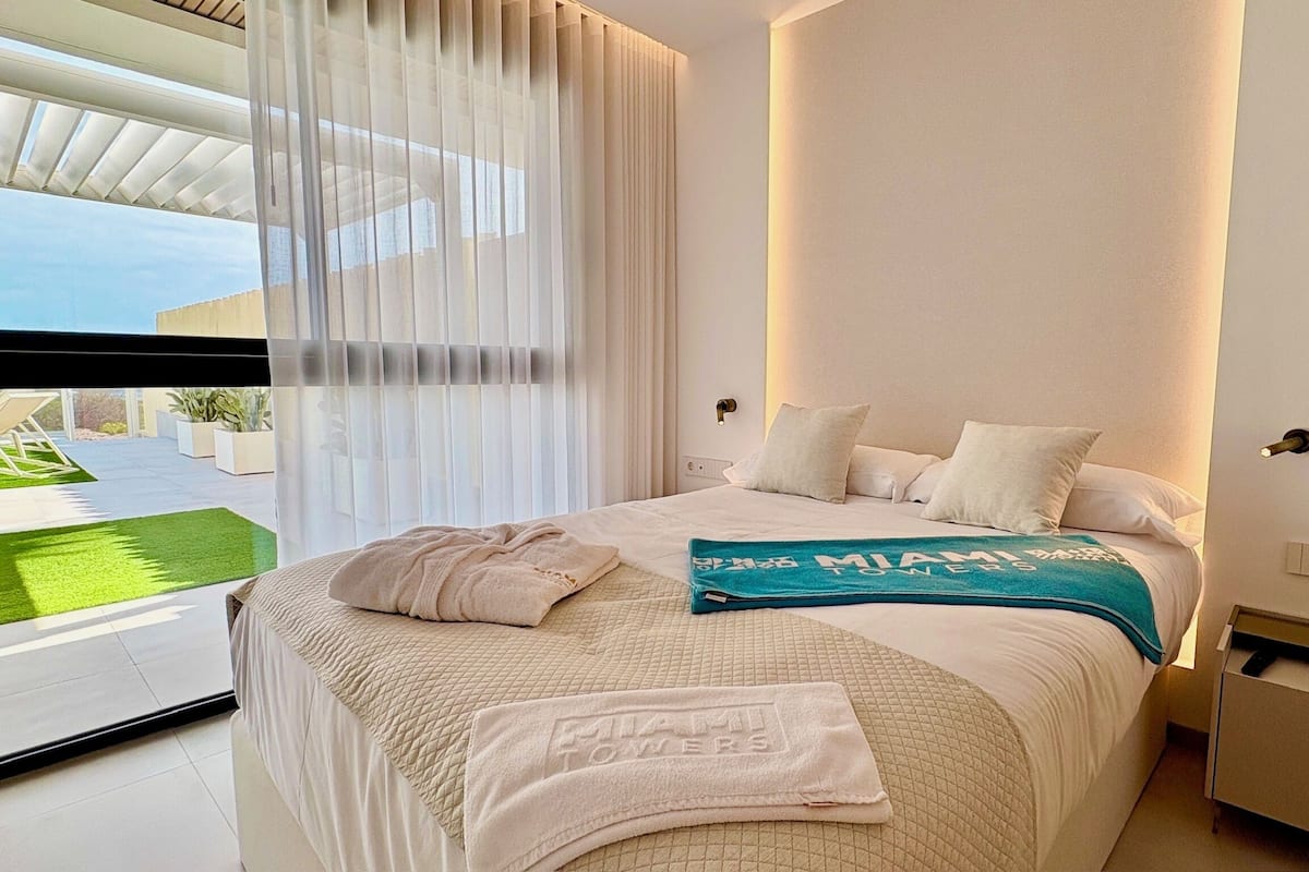 Une chambre d’hôtel moderne avec un grand lit, une vue sur l’extérieur et un balcon.