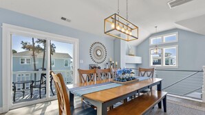 Un coin repas avec une table en bois, des chaises et un lustre.