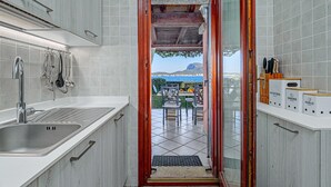 Eine Küche mit Spüle, Besteck und Blick ins Freie.