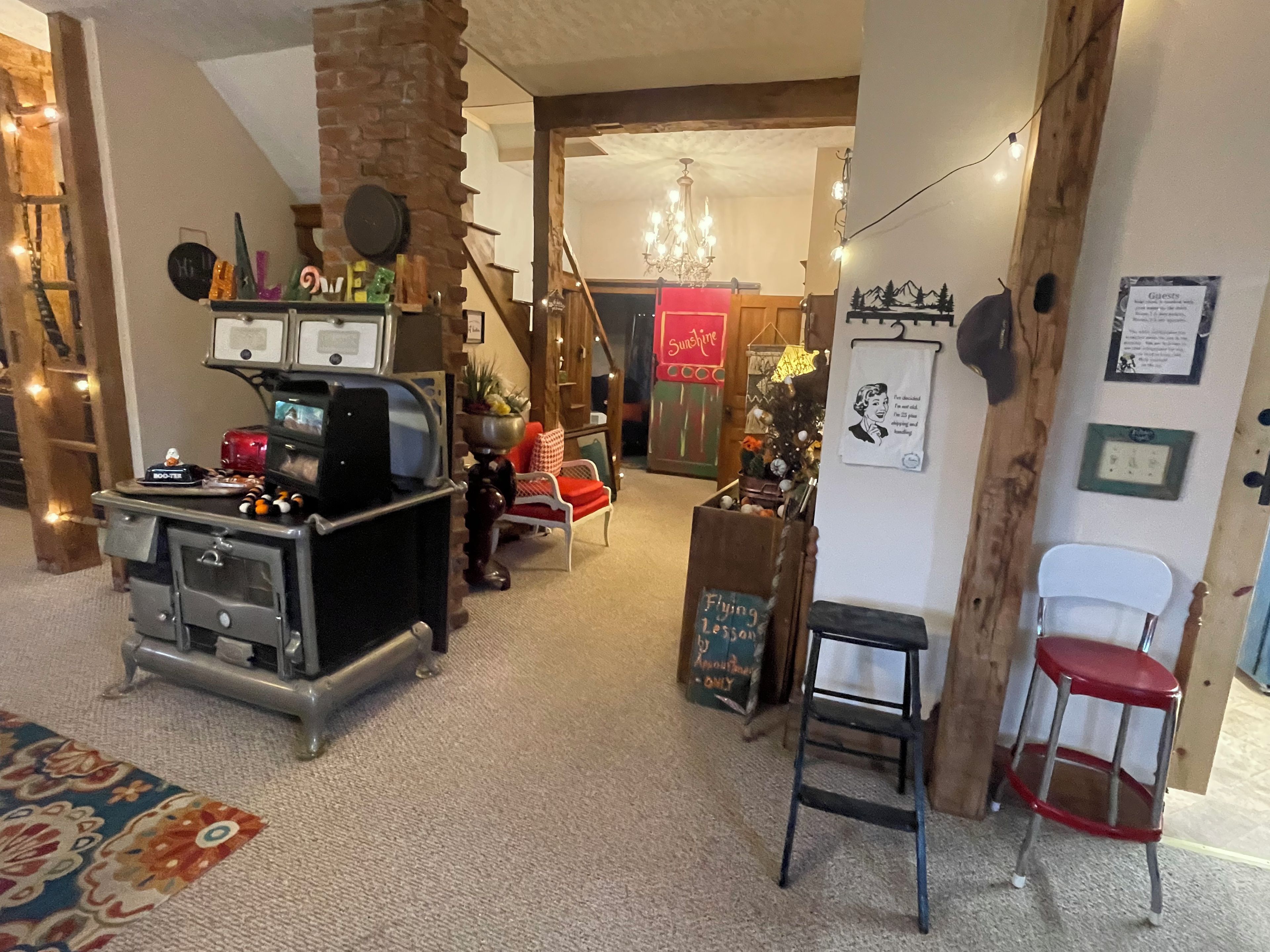 A cozy interior with a vintage radio, a wooden staircase, and a chandelier.