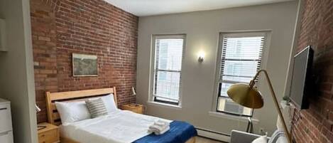 Escritorio, tabla de planchar con plancha, wifi y ropa de cama