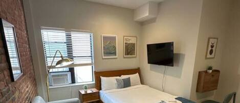 Escritorio, tabla de planchar con plancha, wifi y ropa de cama