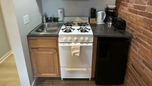 Uma cozinha compacta com armários de madeira, fogão branco e lava-louças preta.