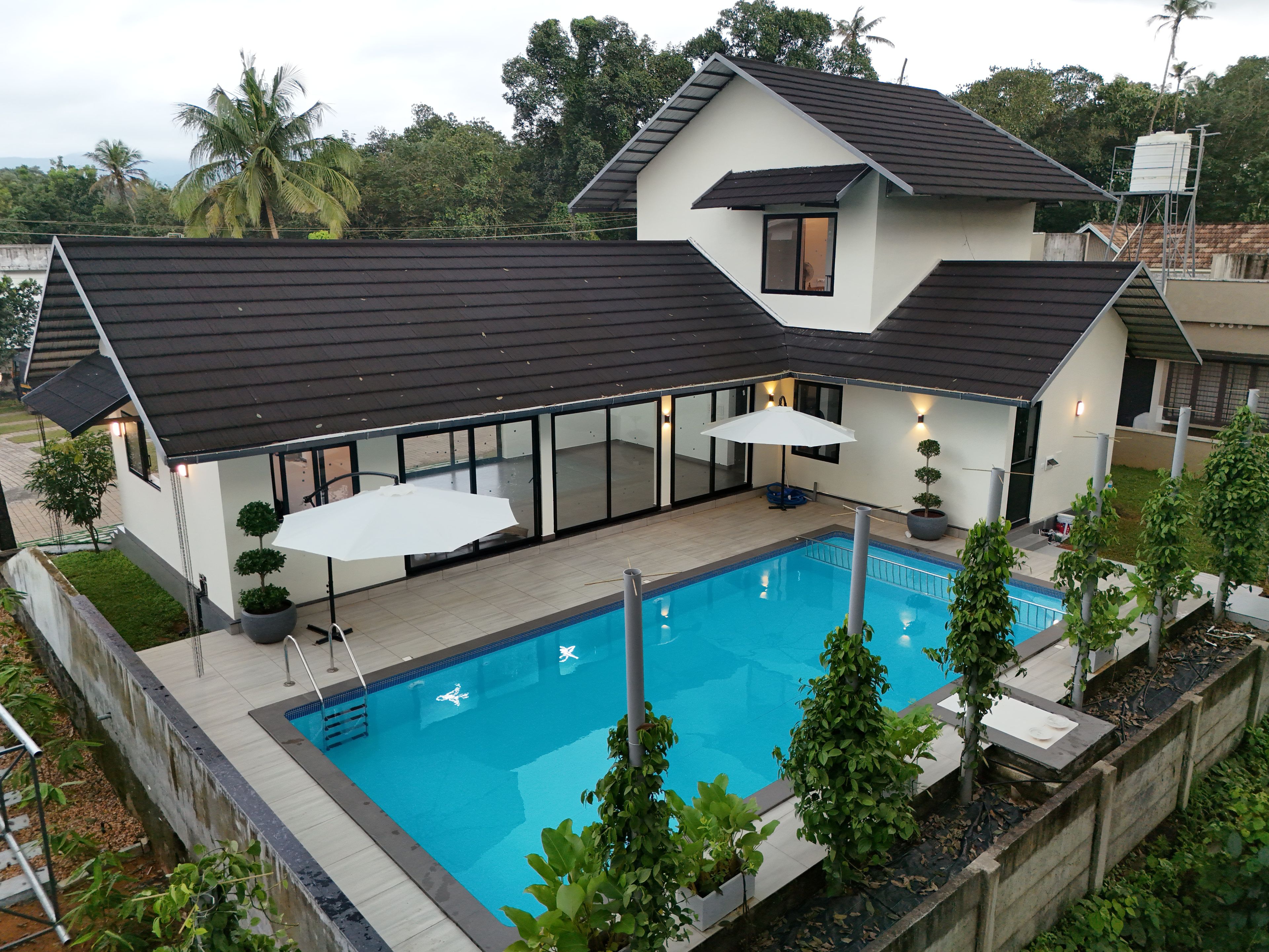 A modern house with a swimming pool, large windows, and a covered patio area.