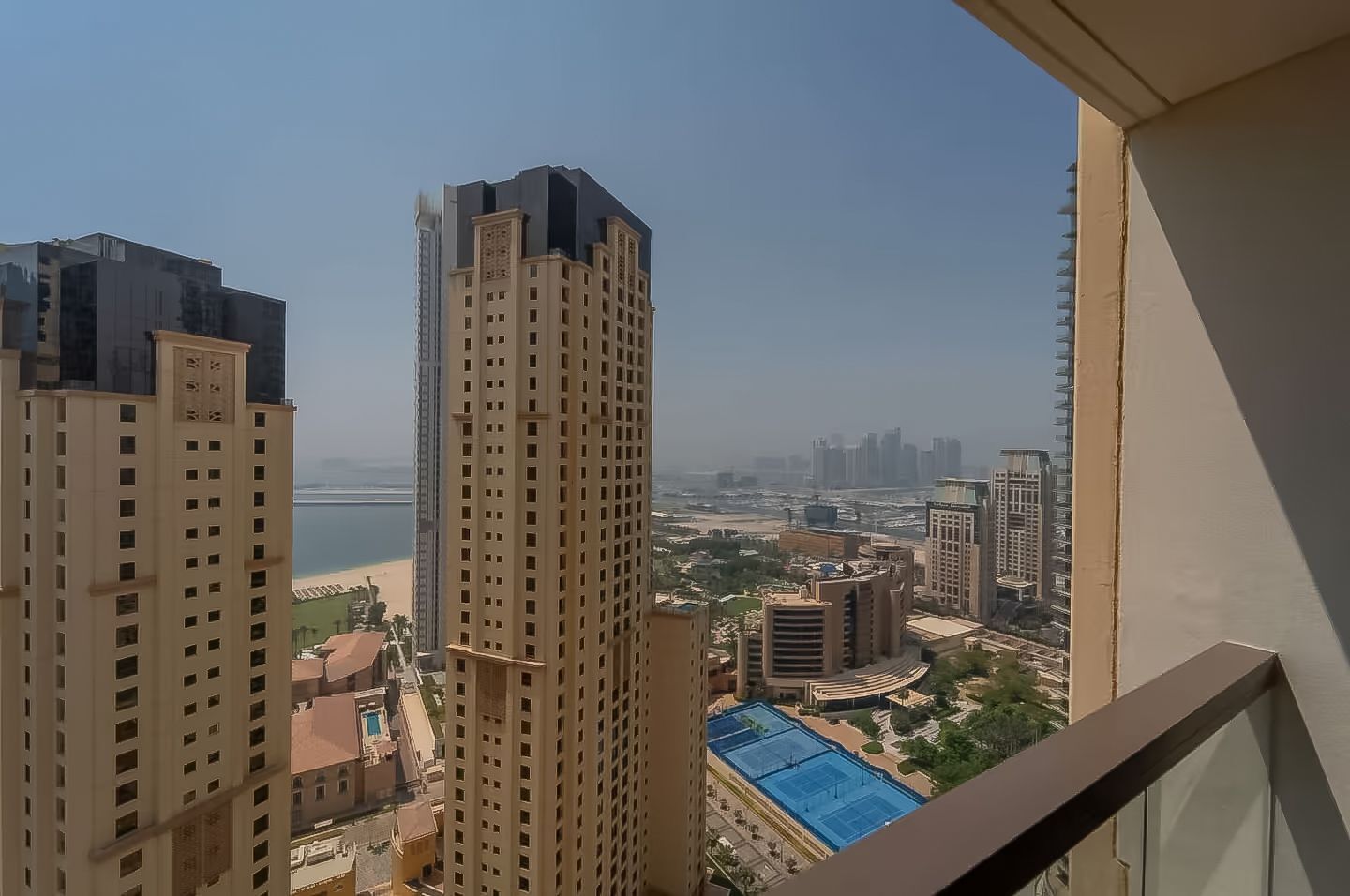 Un edificio alto con vistas a una playa y otros edificios a lo lejos.