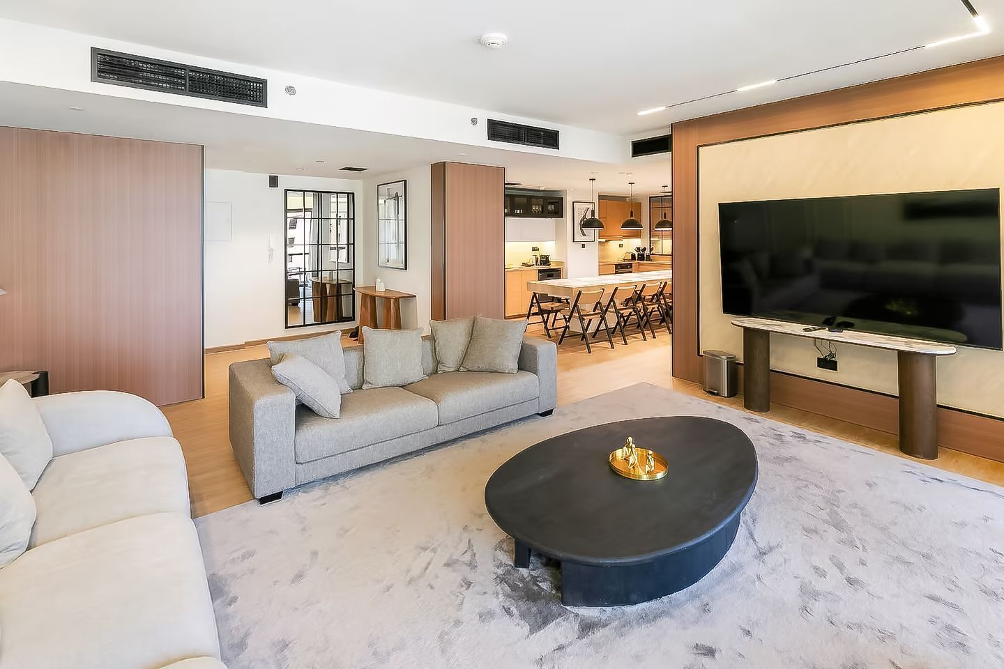 A modern living room with a sofa, a coffee table, and a TV.