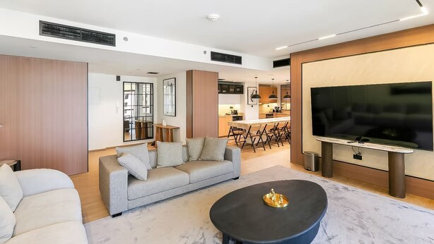 Een moderne woonkamer met een bank, een salontafel en een televisie.