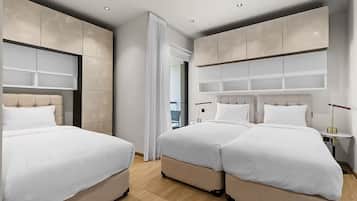 Een moderne hotelkamer met twee bedden, een groot raam en een minimalistisch design.