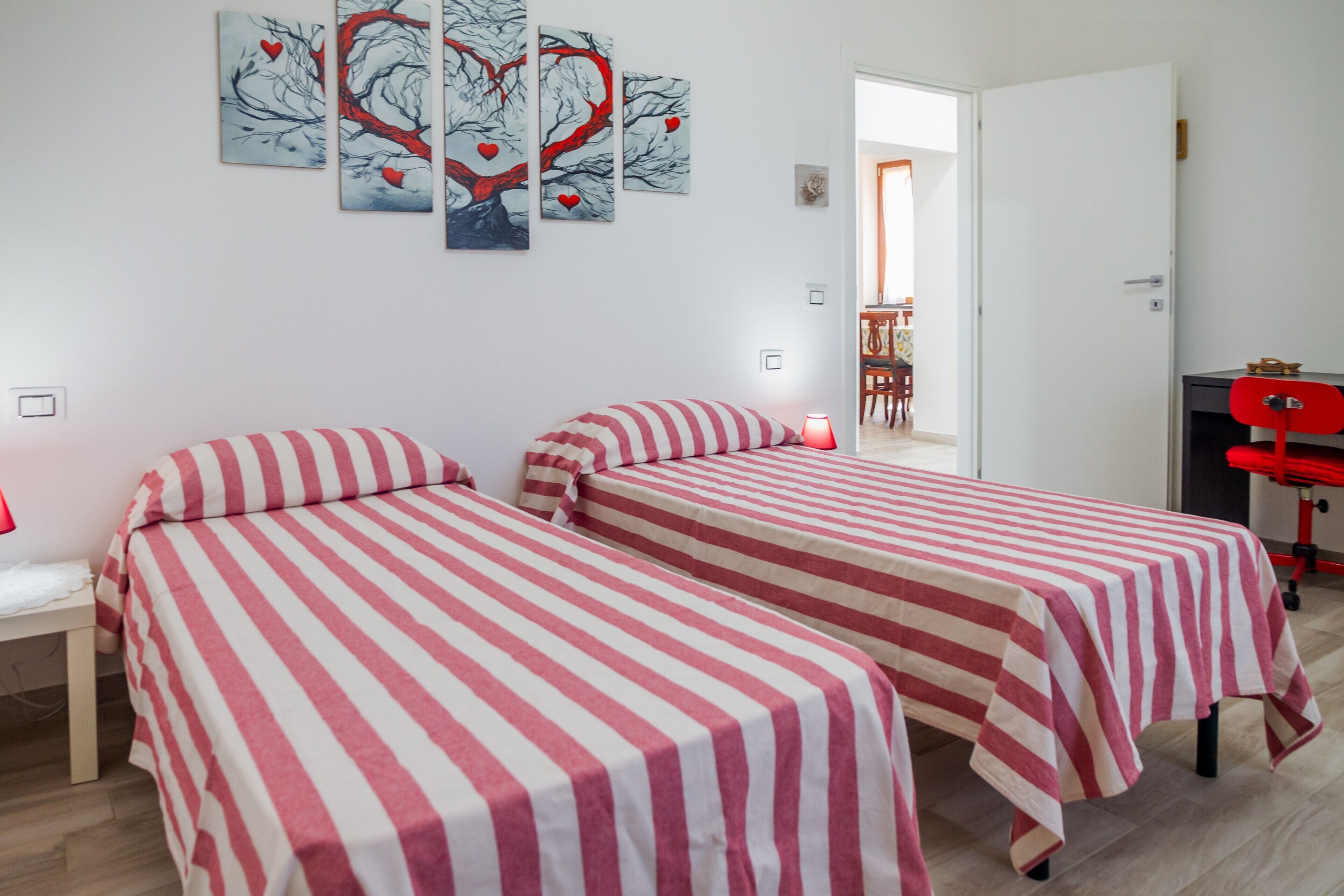 Ein Zimmer mit zwei Betten, einem Schreibtisch und einem Stuhl.