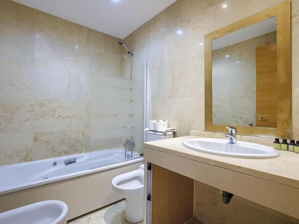A modern bathroom with a bathtub, a toilet, and a sink. - Dobo Getafe Bercial (Getafe)