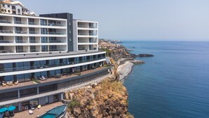 Un hotel moderno con varios balcones con vistas a la costa.
