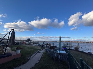 Een terras aan het meer met buitenmeubilair, een prieel en uitzicht op het water.