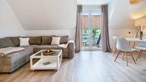 Una sala de estar moderna con un sofá, una mesa de centro y una zona de comedor.